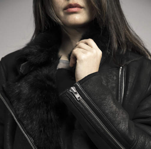 Woman wearing a black fur-lined jacket.