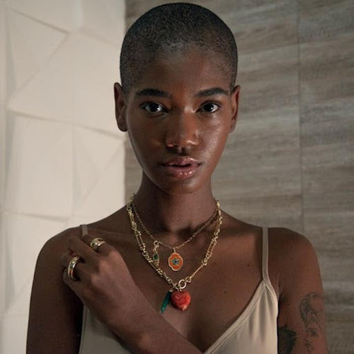 Woman wearing two designer necklaces.