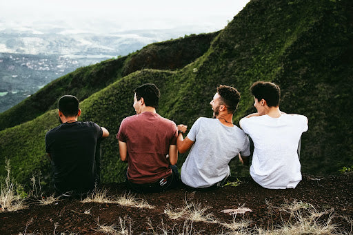 4 men sitting on a mountain.