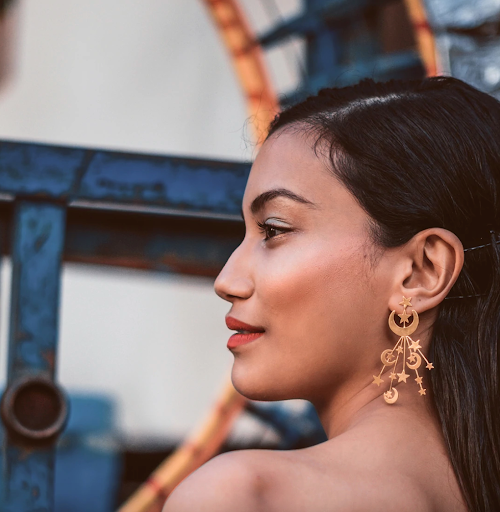 Model wearing unique gold earrings
