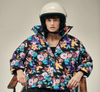 Model wearing helmet and designer coat.