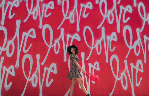 The word love is spray-painted on a wall.