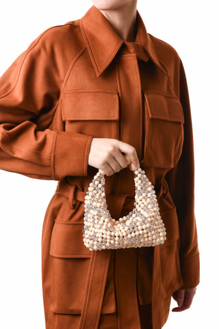 Transparent and beige beaded Jodie bag carried by hand
